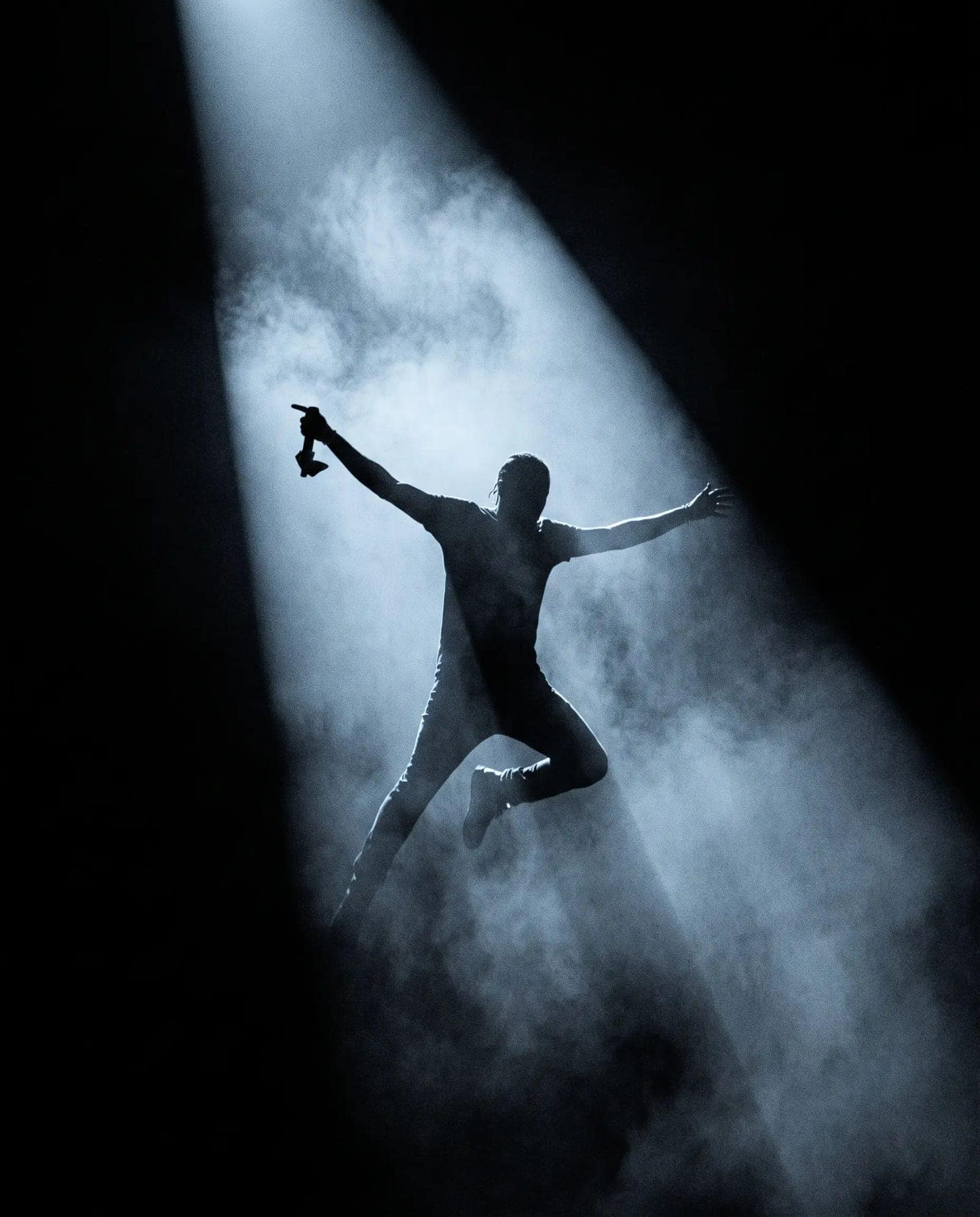 Spotlight Smoke Silhouette, One beam through smoke, a figure inside it, everything else gone
